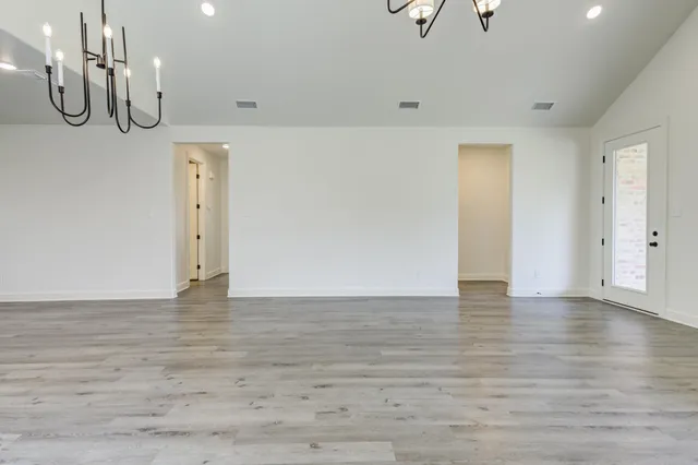 a view of a room with wooden floor and mirror
