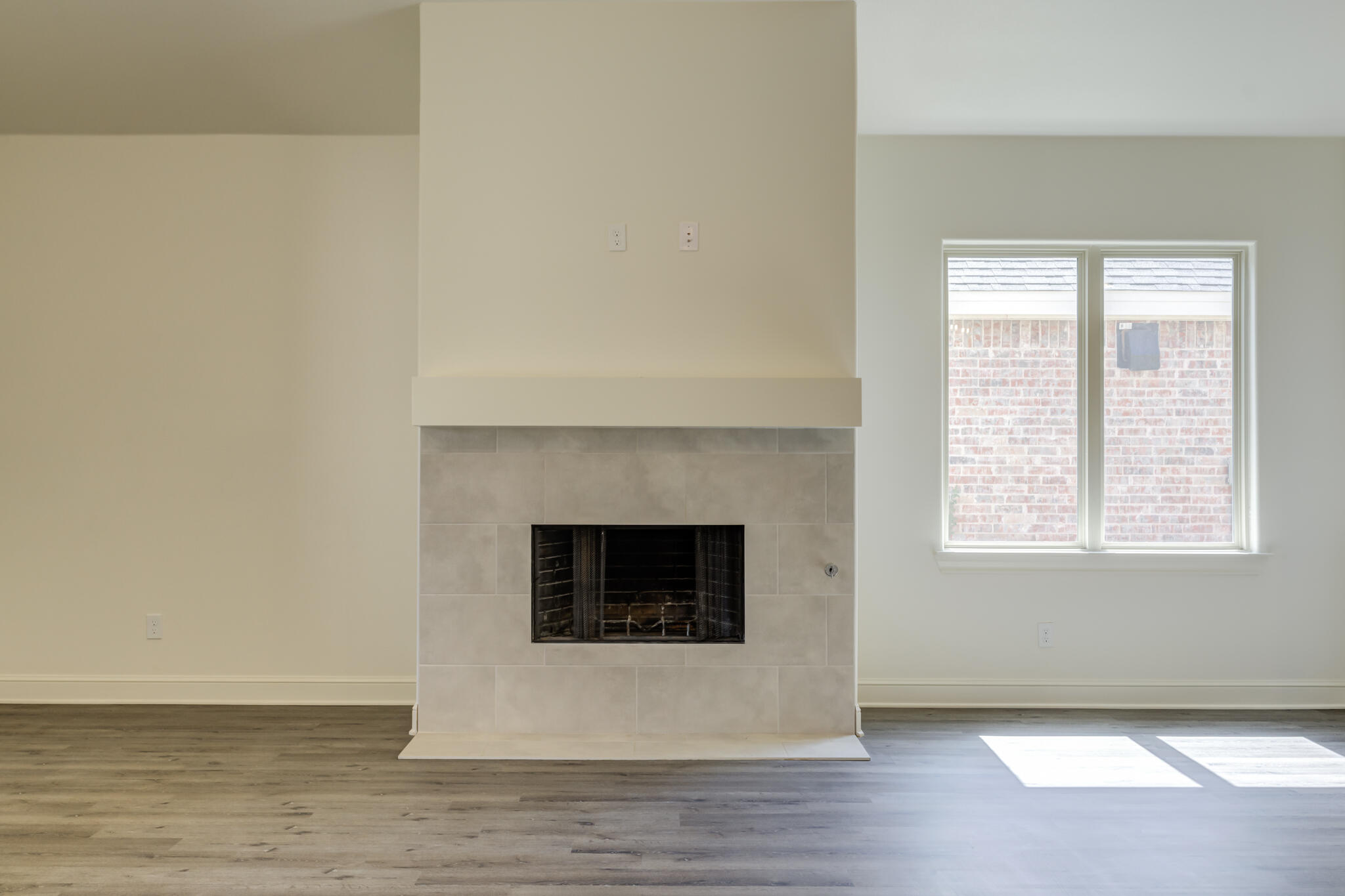 6904 55th Street Lubbock, TX 79407 - Photo 23 of 47 a view of an empty room with wooden floor and a fireplace