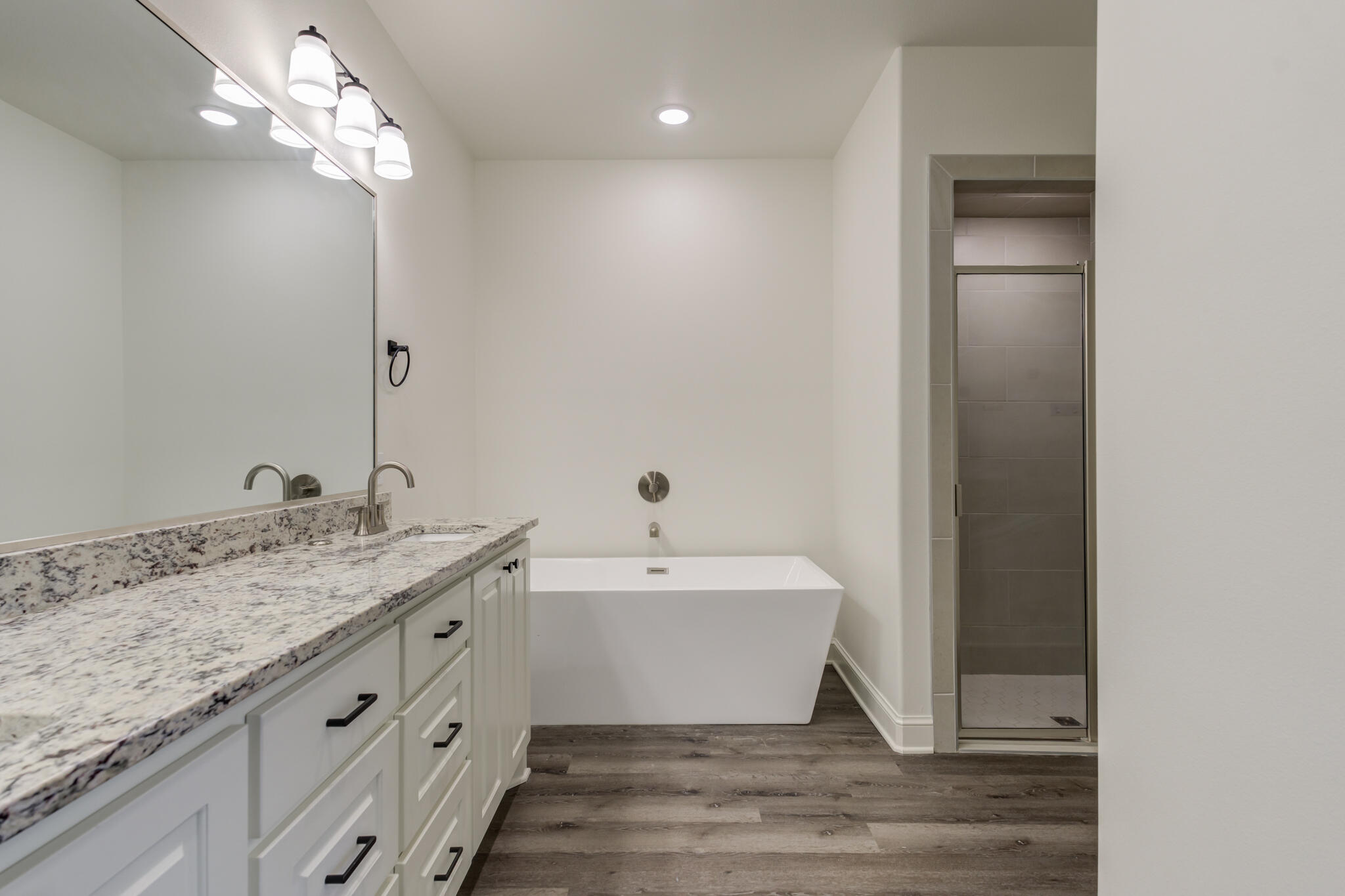 6904 55th Street Lubbock, TX 79407 - Photo 28 of 47 a spacious bathroom with a granite countertop sink a mirror and shower