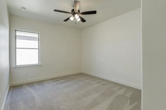 an empty room with a chandelier fan