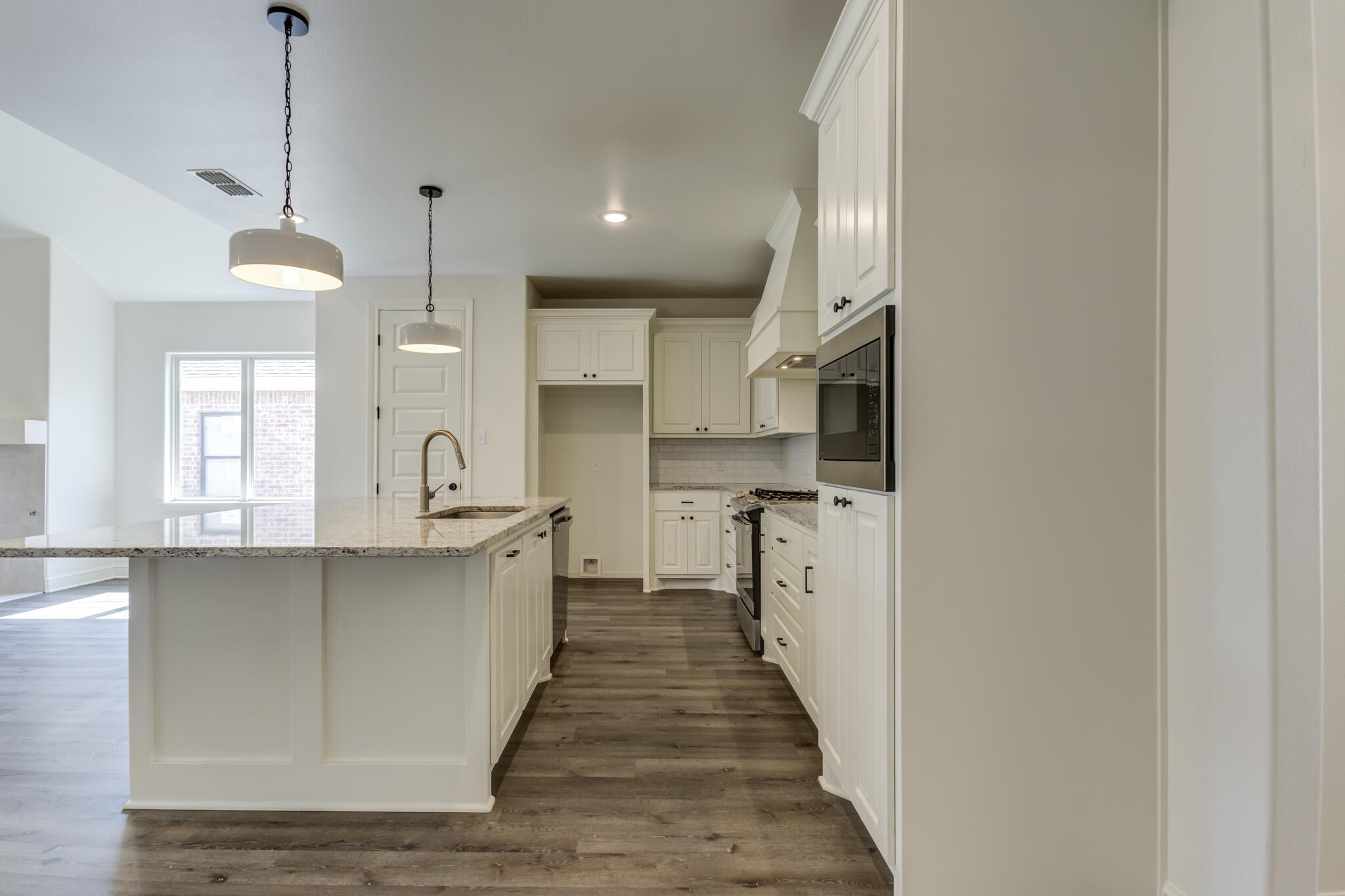 6904 55th Street Lubbock, TX 79407 - Photo 8 of 47 a kitchen with stainless steel appliances granite countertop a sink a stove and a wooden floors