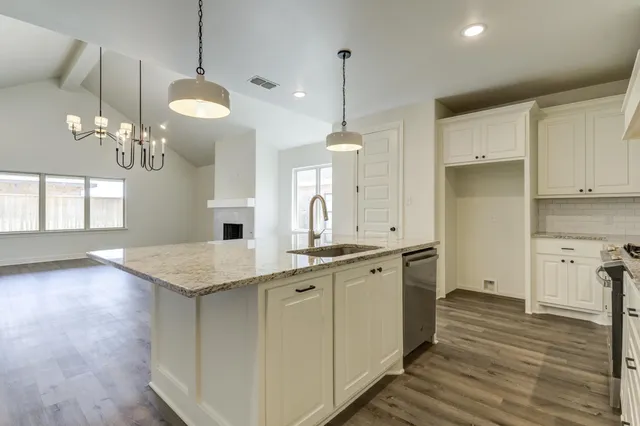 a view of a kitchen counter space a sink wooden floor and a window