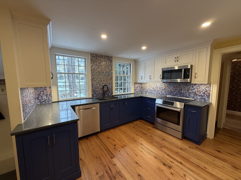 31 Fells Road Winchester, MA 01890 - Photo 8 of 22 a kitchen with granite countertop counter top space a sink stainless steel appliances and windows