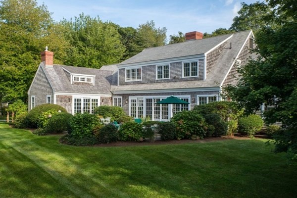 a aerial view of a house next to a big yard and large trees