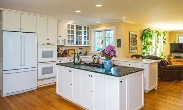 a kitchen with granite countertop a sink stainless steel appliances and cabinets