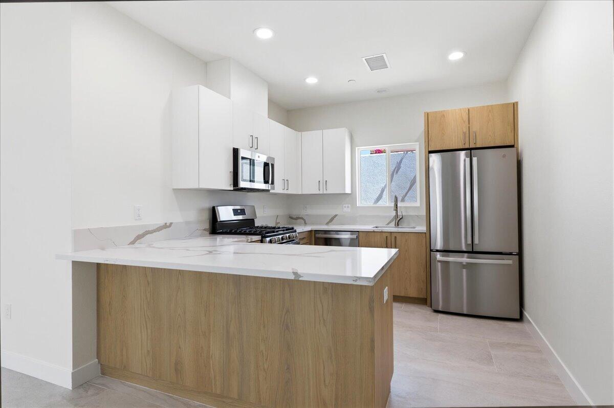 68160 Modalo Road Cathedral City, CA 92234 - Photo 41 of 57 a kitchen with stainless steel appliances granite countertop a refrigerator a sink a stove a microwave and island