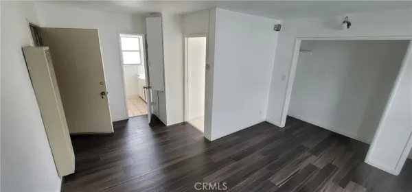 an empty room with wooden floor and closet