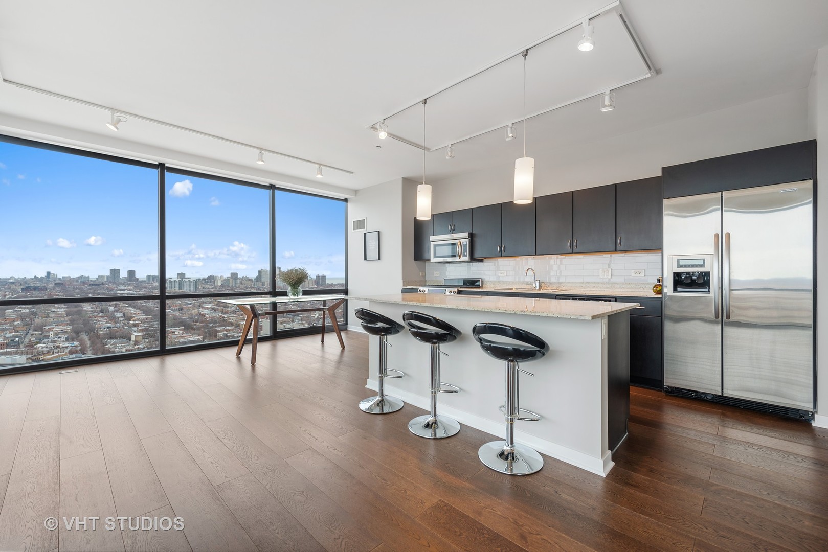 860 West Blackhawk Street, Unit 2803 Chicago, IL 60642 - Photo 6 of 17 a kitchen with stainless steel appliances granite countertop a stove a sink refrigerator and island with wooden floor