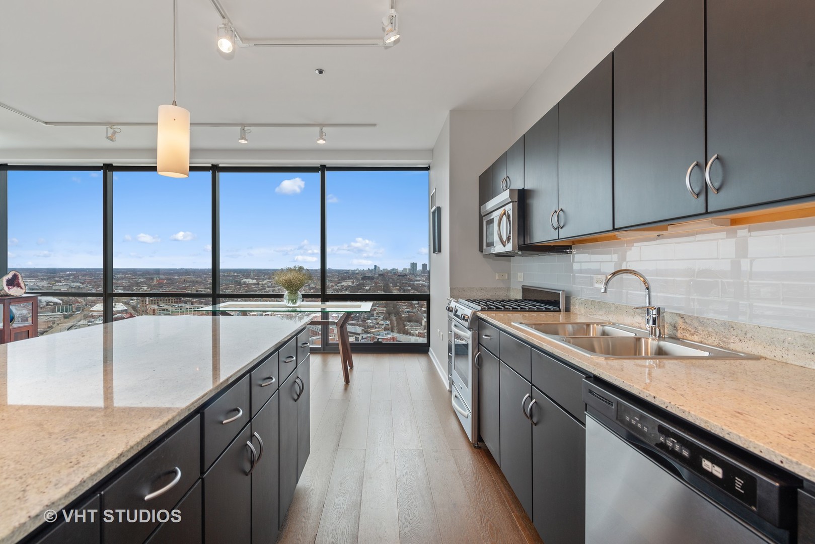 860 West Blackhawk Street, Unit 2803 Chicago, IL 60642 - Photo 8 of 17 a kitchen with kitchen island granite countertop a sink a counter top space cabinets and stainless steel appliances