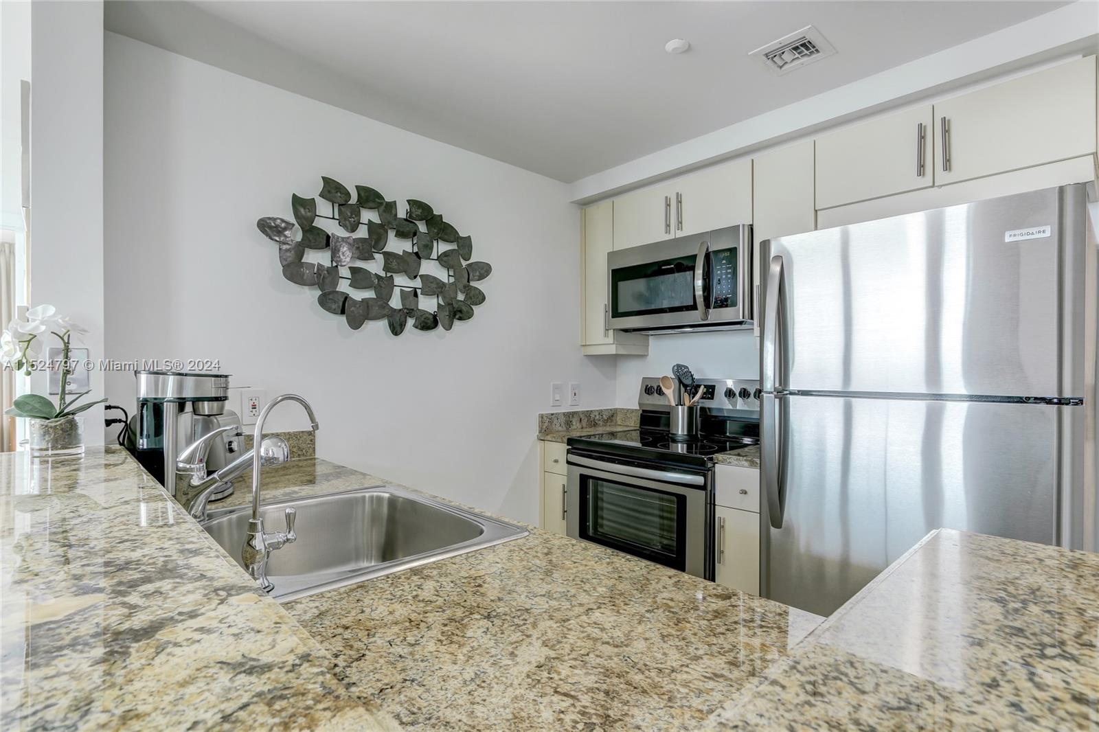 2889 McFarlane Road, Unit 2017 Coconut Grove, FL 33133 - Photo 4 of 19 a kitchen with stainless steel appliances granite countertop a sink stove and refrigerator