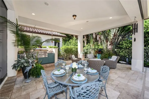 a swimming pool with outdoor seating and a potted plant