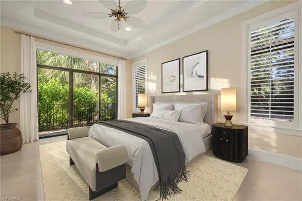 a bedroom with a bed a table and a chandelier