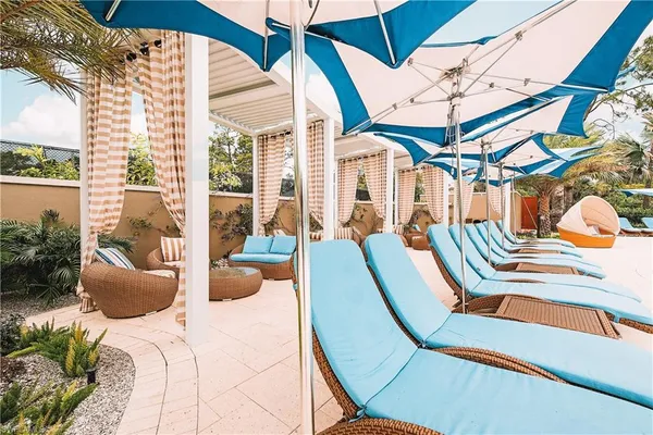 a outdoor space with lots of tables a chairs and chandelier