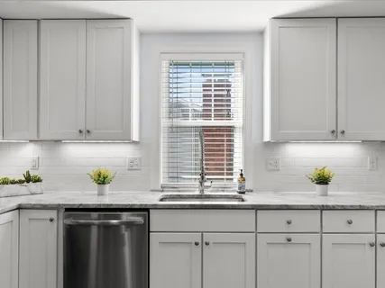 a kitchen with white cabinets and stainless steel appliances