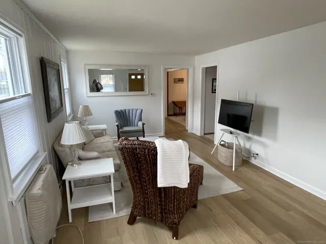 a living room with furniture wooden floor and a flat screen tv