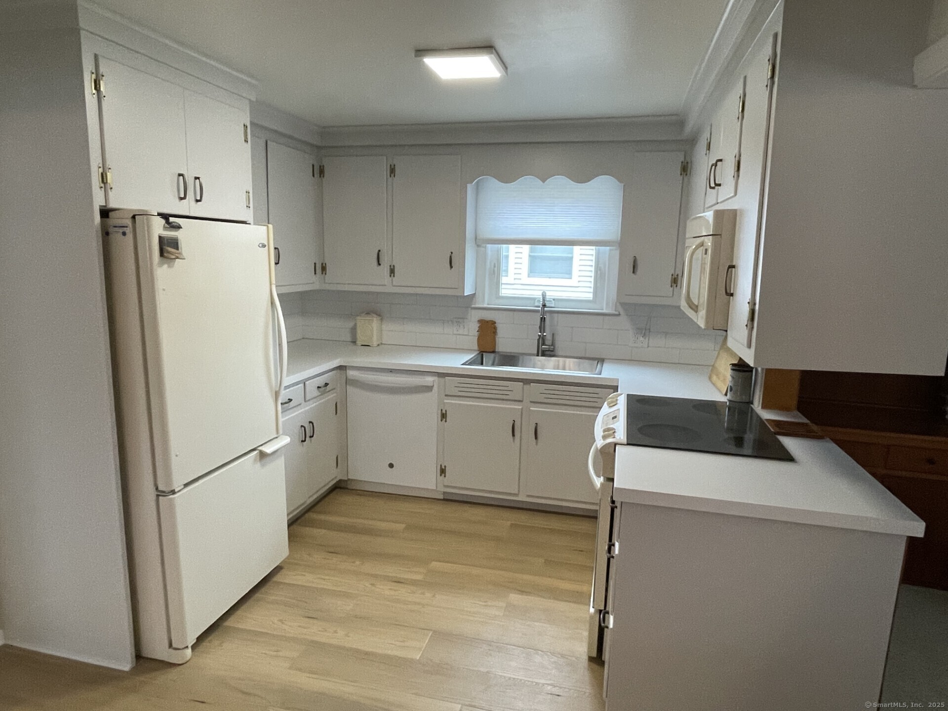 41 Harbor Avenue Madison, CT 06443 - Photo 7 of 27 a kitchen with a sink a refrigerator and cabinets