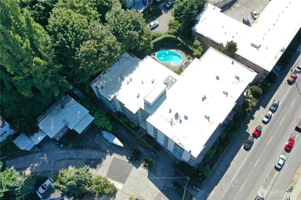 an aerial view of a house with a yard and a large tree