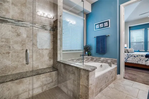 a en suite bathroom with a granite countertop tub sink and shower