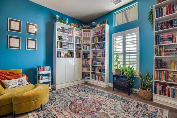 a living room with furniture and a book shelf