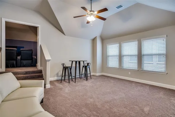 a living room with furniture and a ceiling fan