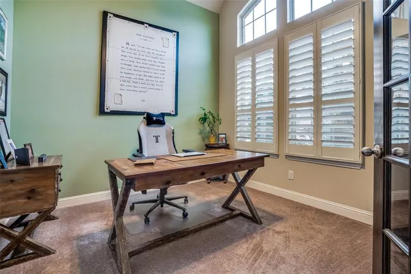 a view of a workspace with furniture and a window