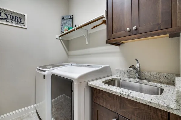 a utility room with sink dryer and washer