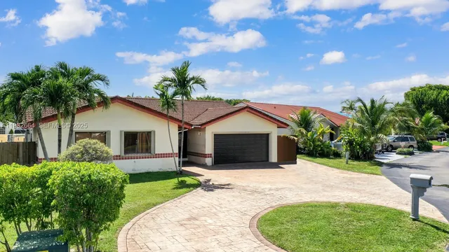 a front view of a house with a garden and yard