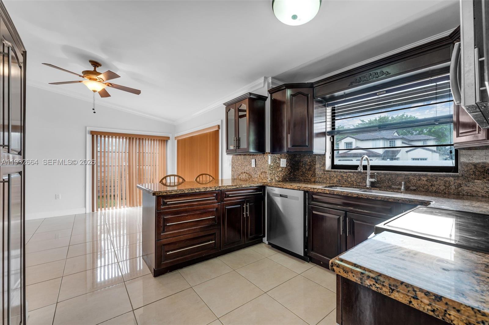 10290 Southwest 145th Place Miami, FL 33186 - Photo 16 of 50 a kitchen with stainless steel appliances granite countertop a refrigerator and a sink