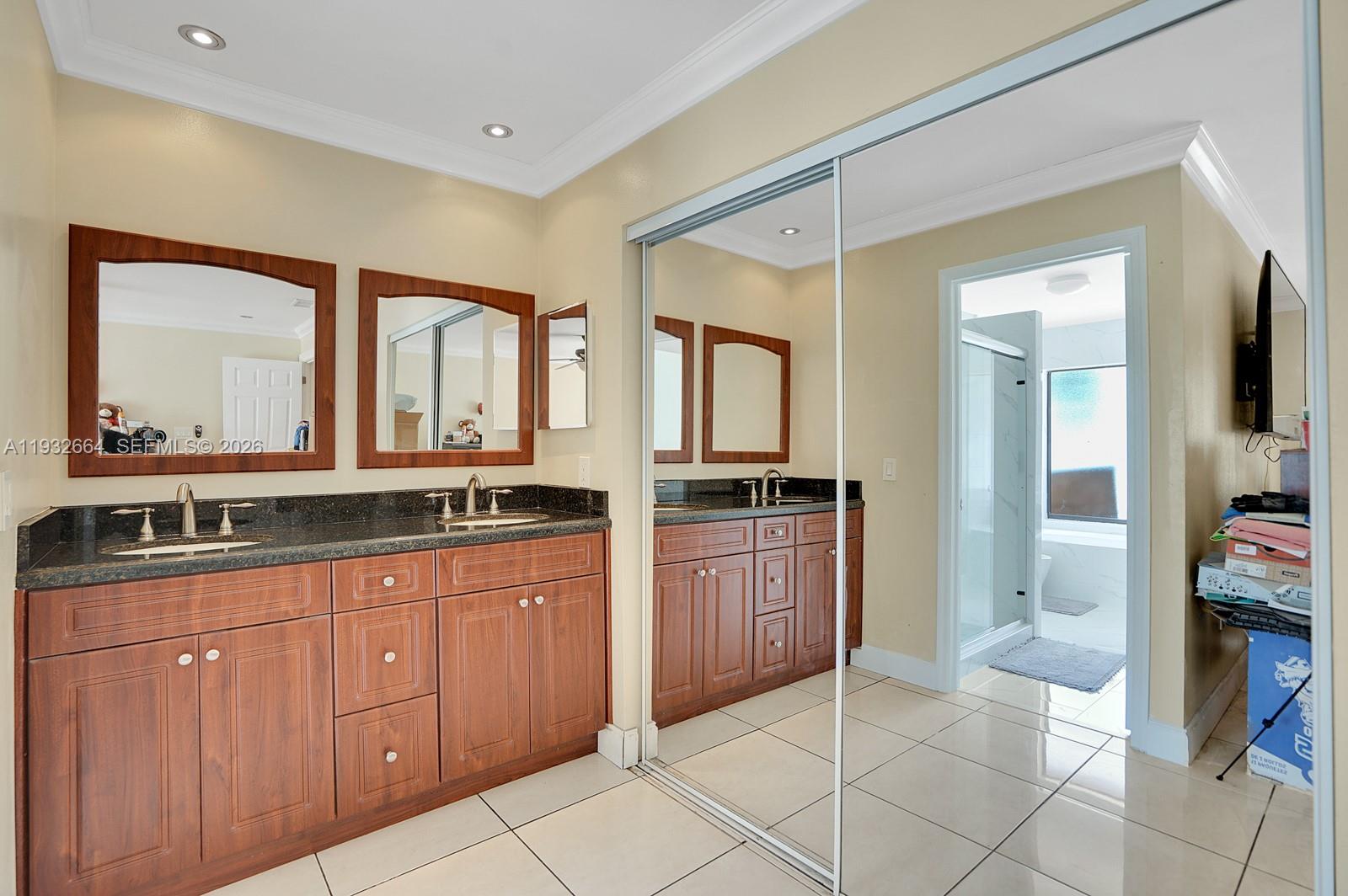 10290 Southwest 145th Place Miami, FL 33186 - Photo 20 of 50 a spacious bathroom with a granite countertop sink and mirror