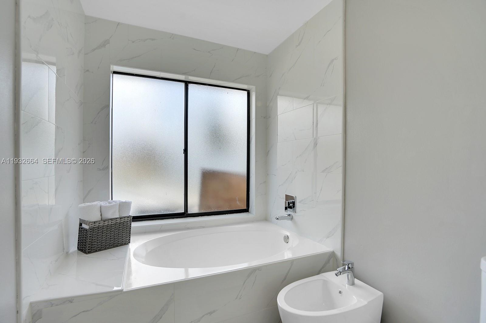 10290 Southwest 145th Place Miami, FL 33186 - Photo 23 of 50 a bathroom with a tub sink and mirror