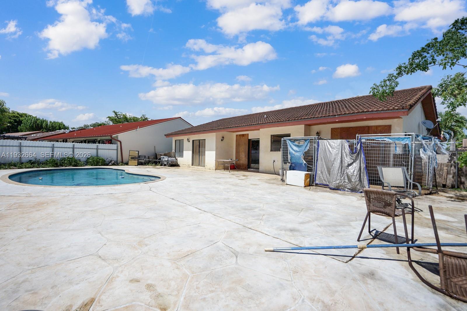 10290 Southwest 145th Place Miami, FL 33186 - Photo 28 of 50 a backyard of a house with table and chairs