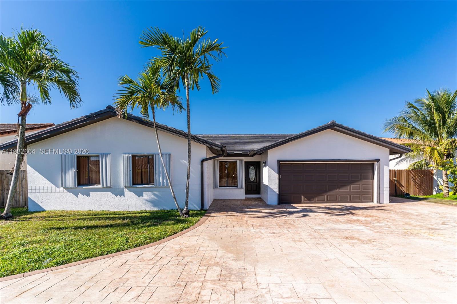 10290 Southwest 145th Place Miami, FL 33186 - Photo 6 of 50 a front view of house with yard and tree in front of it