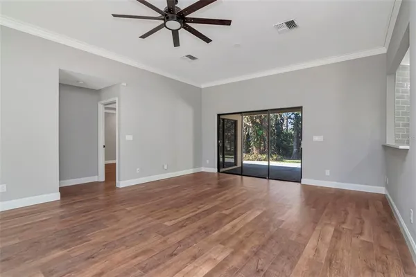 a view of a livingroom with a ceiling fan window and wooden floor