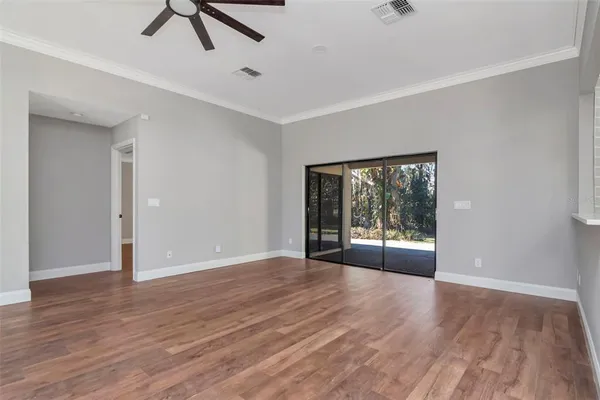 a view of a big room with wooden floor and windows