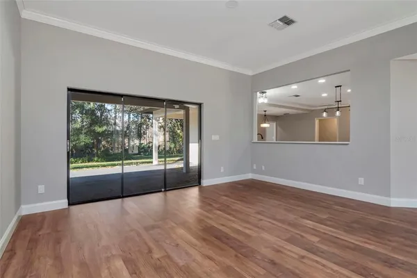 a view of a big room with wooden floor and windows