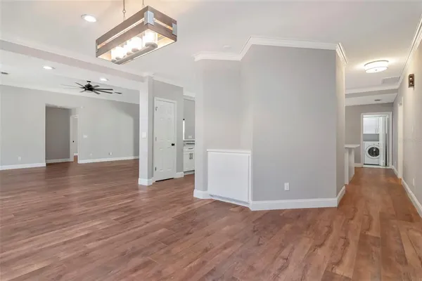a large kitchen with a refrigerator a sink dishwasher a stove and a dining table with wooden floor