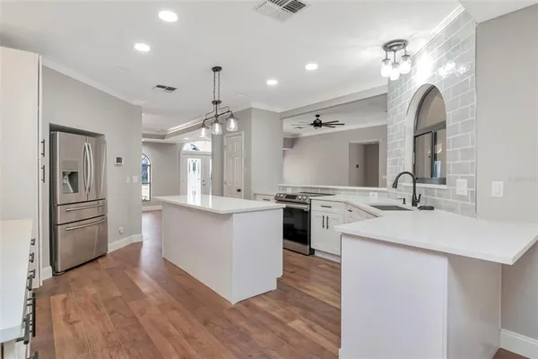 a kitchen with stainless steel appliances a sink stove and refrigerator