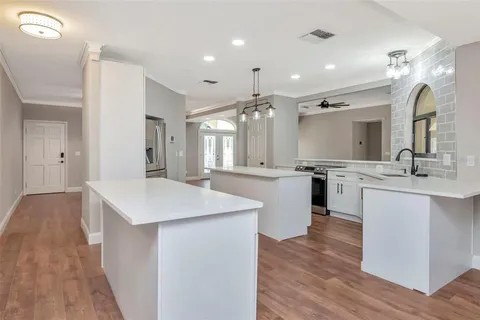 a spacious bathroom with a granite countertop sink a toilet a mirror and vanity