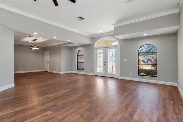 a view of an empty room with window and wooden floor