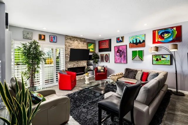 a living room with furniture kitchen view and a flat screen tv