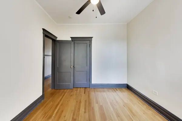 an empty room with wooden floor and natural light