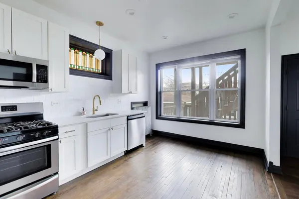 a kitchen with stainless steel appliances a stove sink and microwave