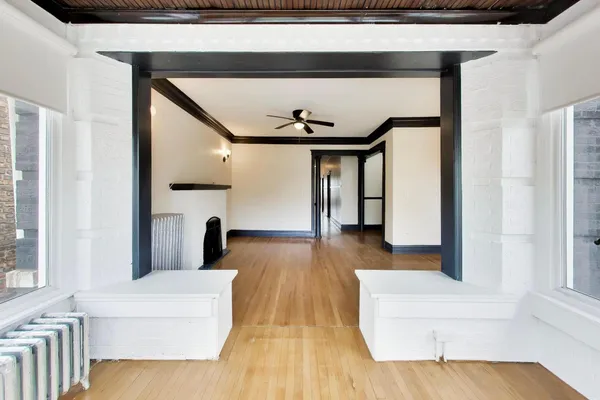 a view of a hallway with wooden floor and staircase