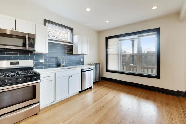 a kitchen with stainless steel appliances granite countertop a stove a sink and a microwave