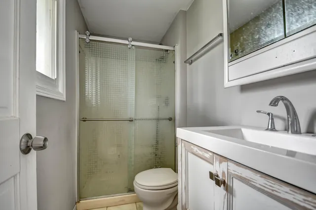 a bathroom with a sink a toilet and shower