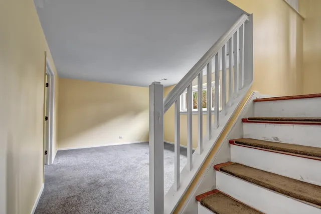 a view of staircase with wooden floor and white walls