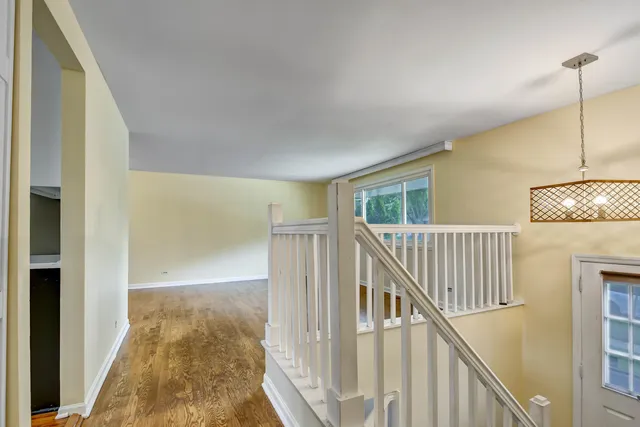 a view of staircase with railing and a chandelier