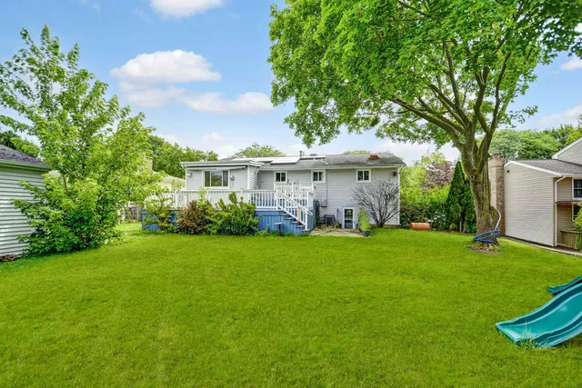 a view of a backyard with couches plants and large trees