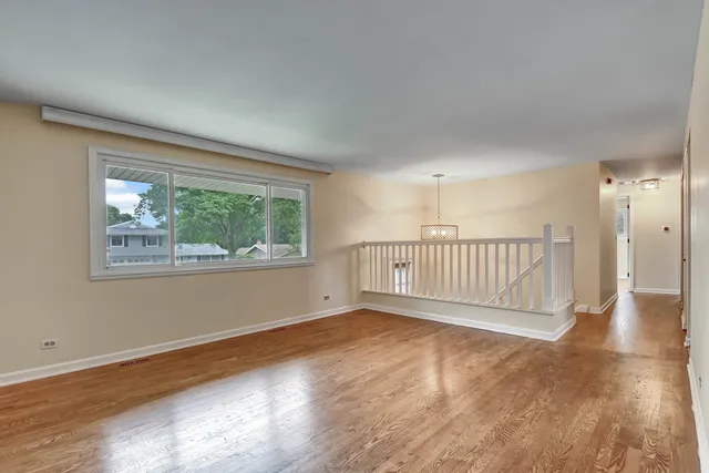 a view of a livingroom with wooden floor and a window