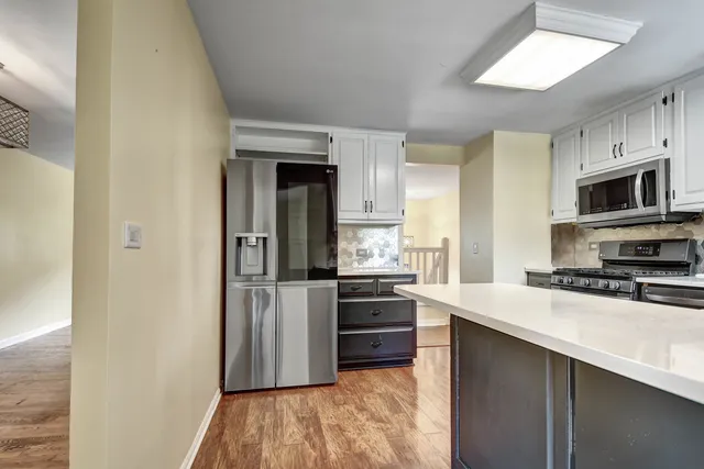 a kitchen with stainless steel appliances granite countertop a refrigerator a stove top oven a sink and dishwasher